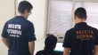 Agentes de costas, de frente para um computador, vestem camiseta com a inscrição Receita Estadual
