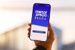 Mão segura um celular com a tela do aplicativo Menor Preço Brasil
