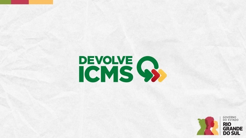 Sobre um fundo cinza, semelhante a um papel amassado, est&aacute; escrito Devolve ICMS na cor verde, ao lado de uma flecha em formato de c&iacute;rculo. 