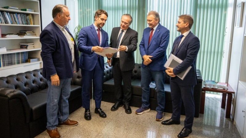 autoridades reunidas, todas de p&eacute;, lendo um documento